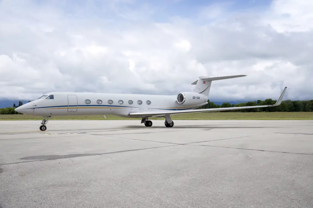 Side view of the Gulfstream G550 on the tarmac, showcasing the aircraft's elegant profile and multiple windows along the fuselage.