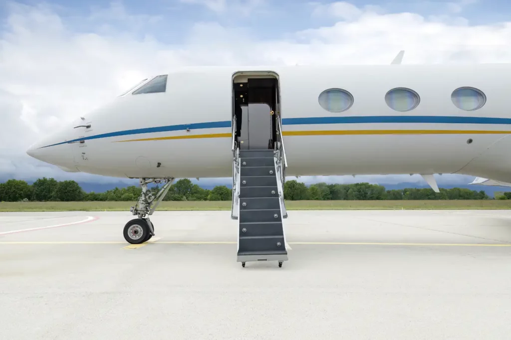 Side view of the Gulfstream G550 with the boarding stairs extended, emphasizing the jet's streamlined design and passenger entry point.