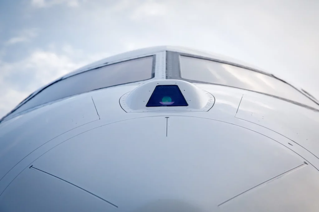 Close-up of the nose section of a Bombardier Global 5000 jet with cockpit windows visible.