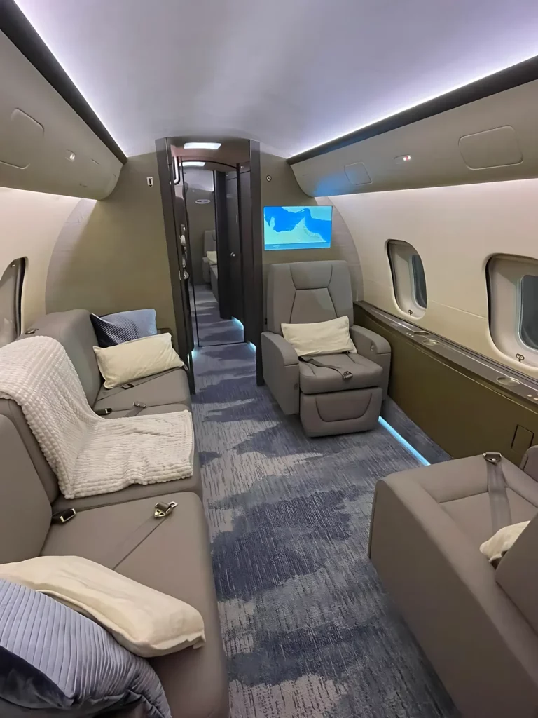 Luxurious aft cabin of a Bombardier Global 5000 jet featuring comfortable seating and modern amenities.