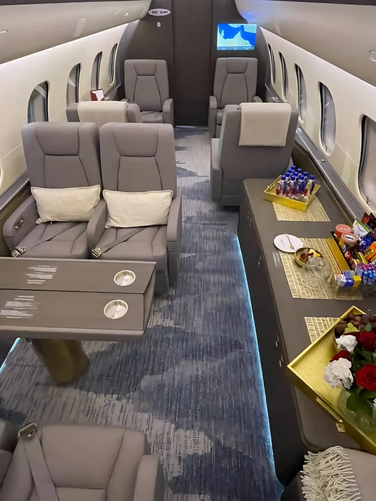 Forward cabin of a Bombardier Global 5000 jet, showcasing a credenza and elegant interior design.