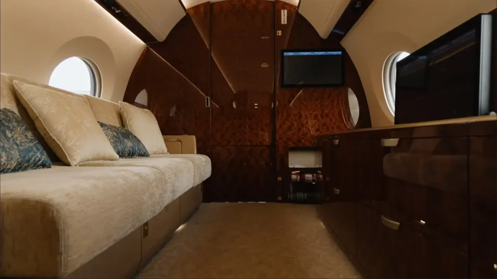 Gulfstream G500 interior featuring two leather seats with a polished wood table and large windows