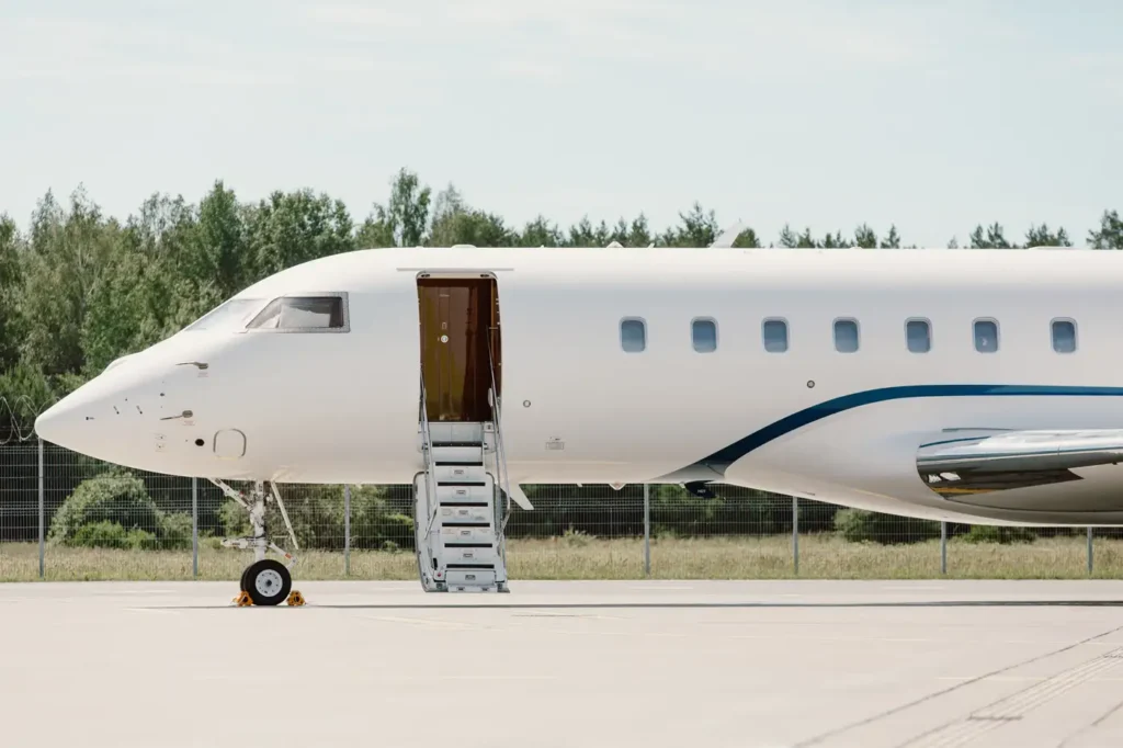 Close-up of Bombardier Global 5000 private jet door with extended stairs, ready for boarding