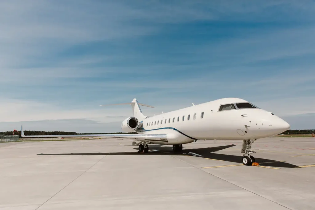 Front three-quarter view of Bombardier Global 5000 private jet on the tarmac under blue skies