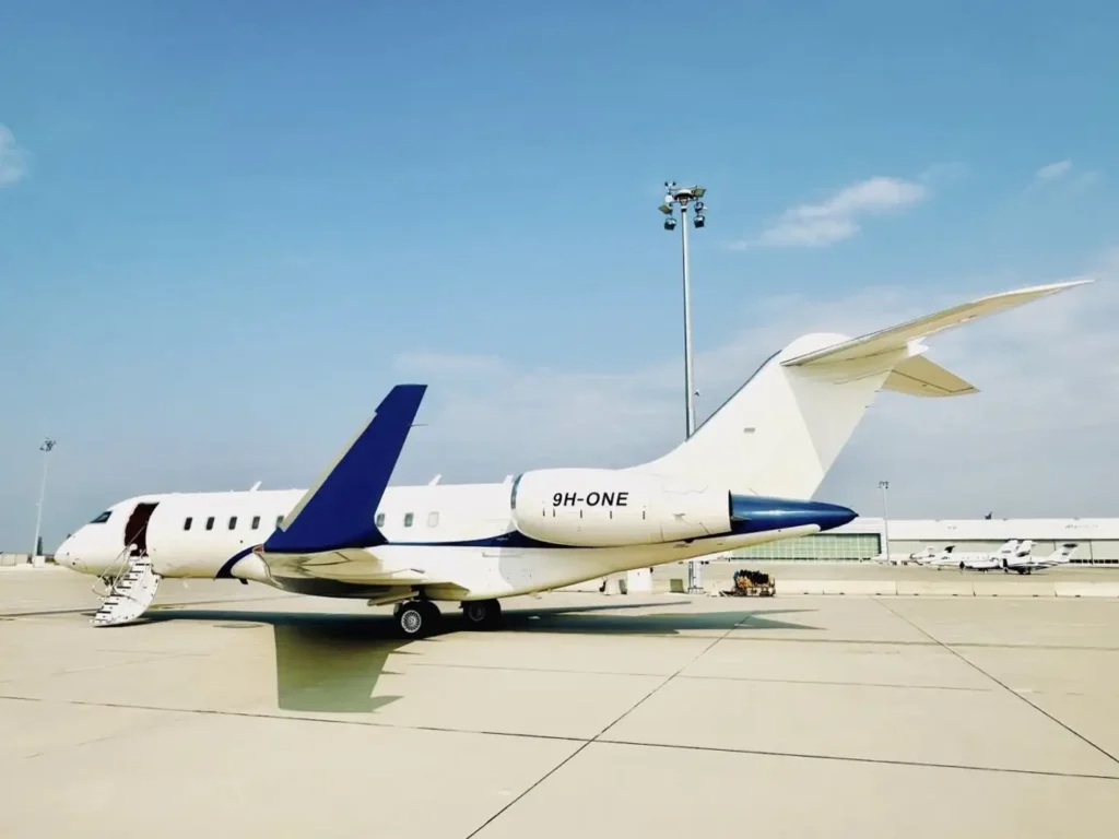 Bombardier Global 5000 private jet parked at an airport with stairs extended under clear skies