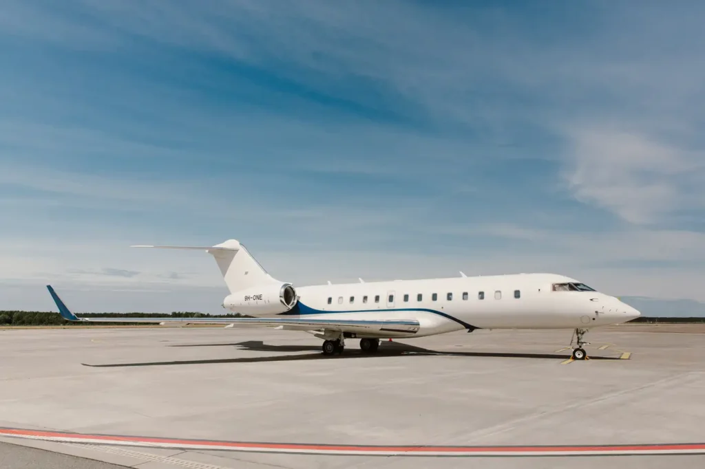 Bombardier Global 5000 private jet parked on the tarmac with engines visible and clear skies in the background