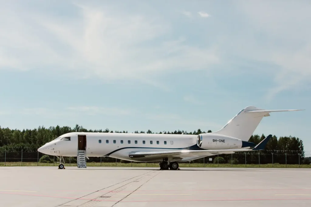 Side view of Bombardier Global 5000 private jet on the tarmac, showcasing sleek design and extended boarding stairs