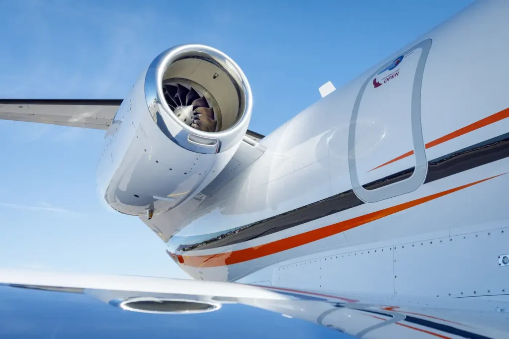 Detailed view of Cessna Citation CJ3 jet engine and fuselage with emergency exit door