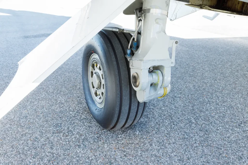 Close-up of Cessna Citation CJ3 landing gear and tire on asphalt runway