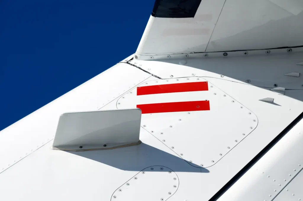 Close-up view of Cessna Citation CJ3 tail with red markings against clear blue sky