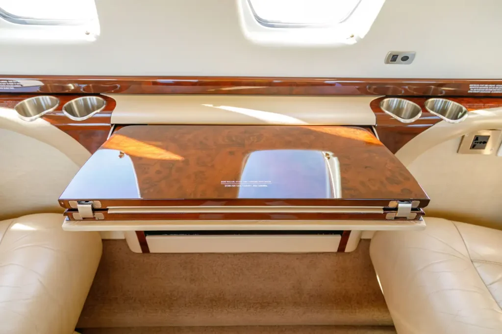 Folding wooden table with luxury wood finish in the cabin of a Cessna Citation CJ3 private jet