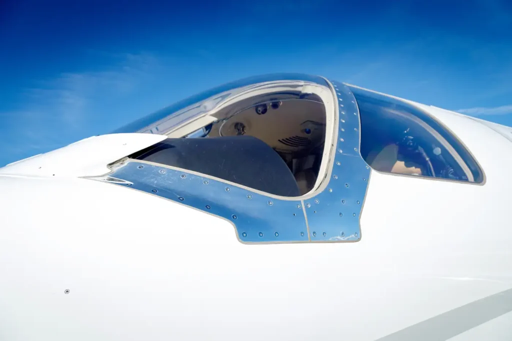 Close-up of Cessna Citation CJ3 cockpit window and fuselage reflecting the sky