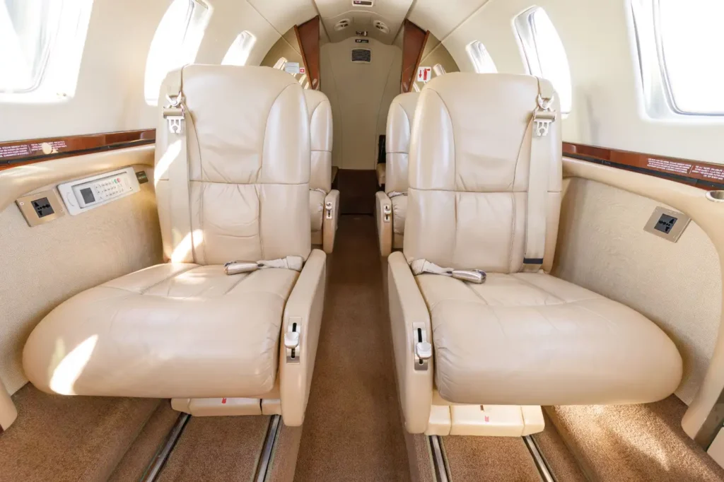 Close-up of two reclining beige leather seats in the Cessna Citation CJ3 private jet cabin