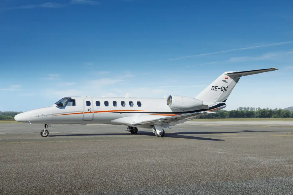 Side view of Cessna Citation CJ3 private jet OE-GIE on runway with blue skies