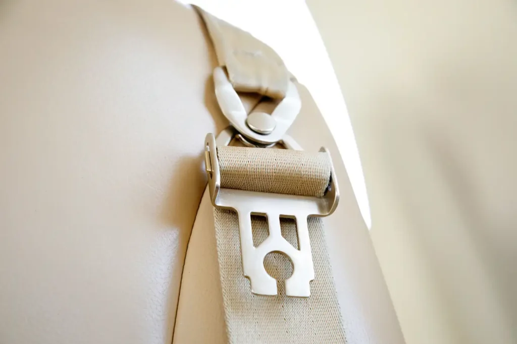 Close-up of seatbelt and beige leather seat inside Cessna Citation CJ3 private jet