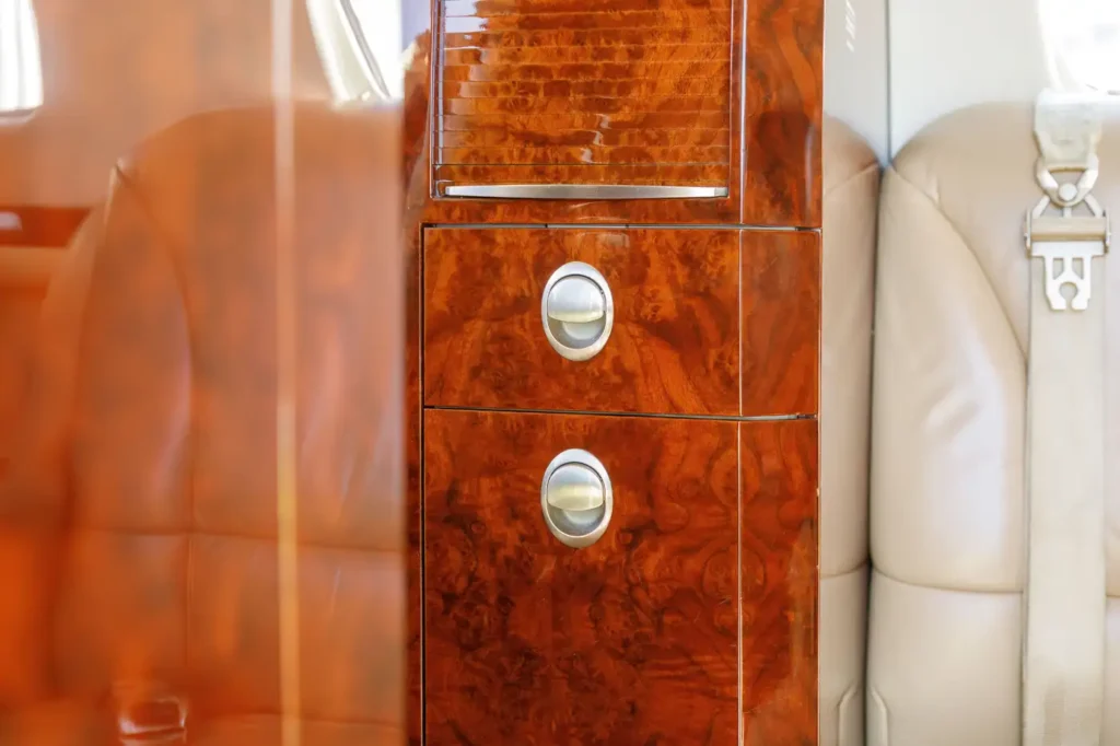 Luxury interior of Cessna Citation CJ3 private jet with wood veneer cabinet and leather seat